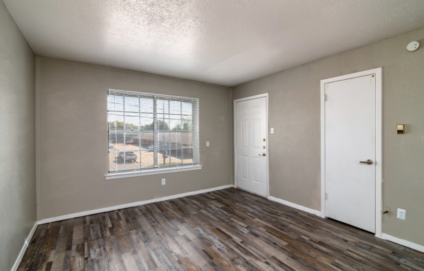 empty room with hardwood floors and a door at The Royal Terrace Apartments